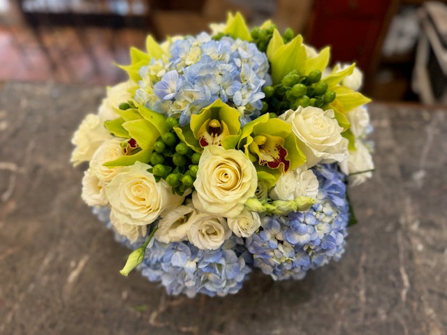 
                    
                      Blue hydrangea, green cymbidium orchids and hypericum berries, and white rose centerpiece – Jerome Florists NYC
                    
                  